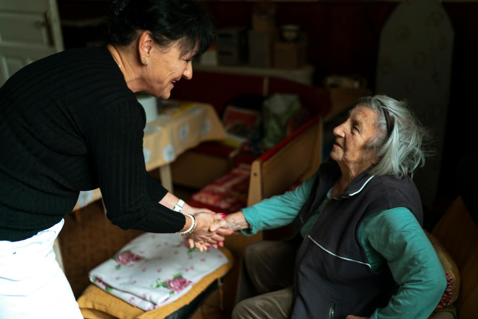Elderly caregiver greets a senior woman at her front door, a common first step in arranging in-home companion care.